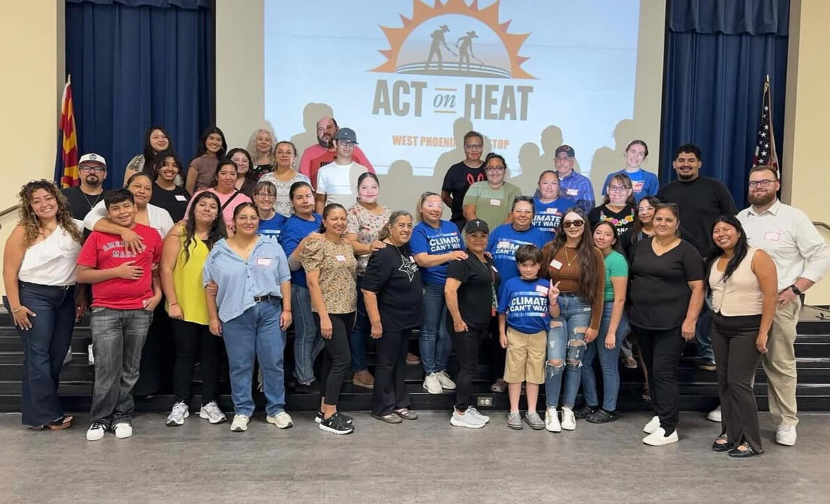 People gathered together for a picture. A few are holding signs that say Climate Can't Wait